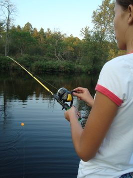 A young fishergirl learned to hook a worm and fish for the first time