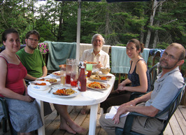 Professor with students relaxing around dinner on the patio